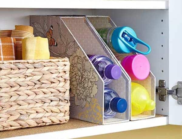 A view of kitchen magazine holder storing water bottles and kept on shelf