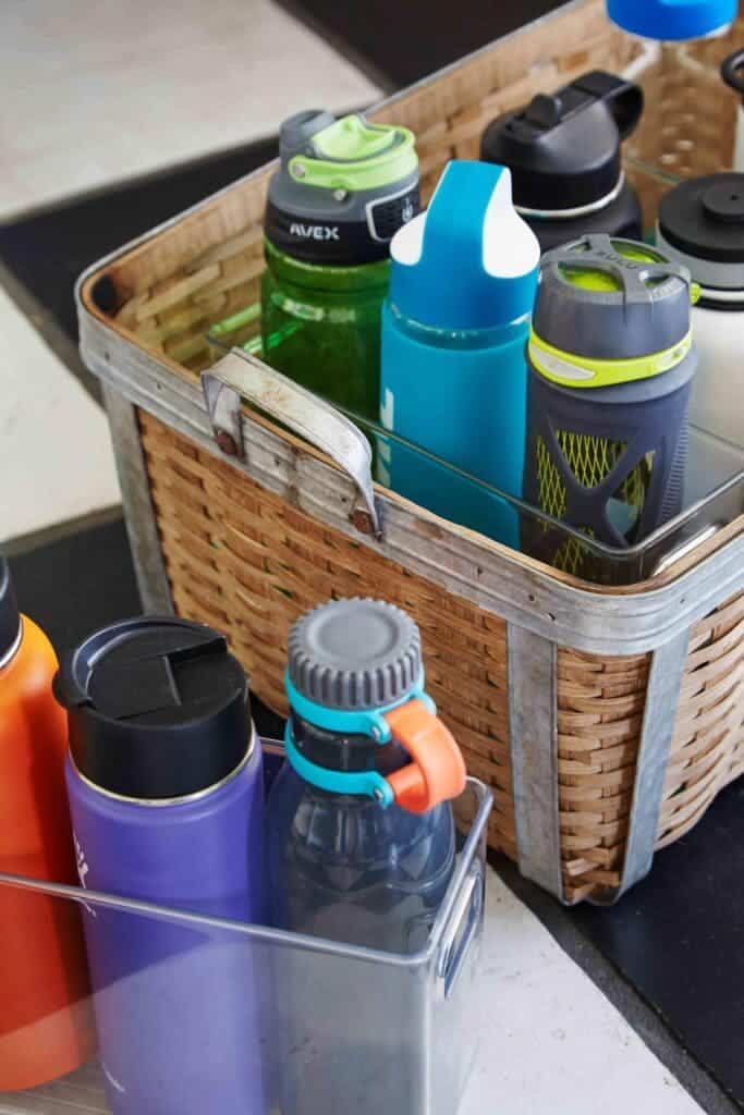 A view of multiple water bottles kept inside a wooden and plastic basket