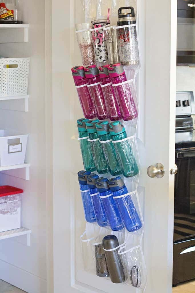 A view of water bottles stored over the door in plastic pockets