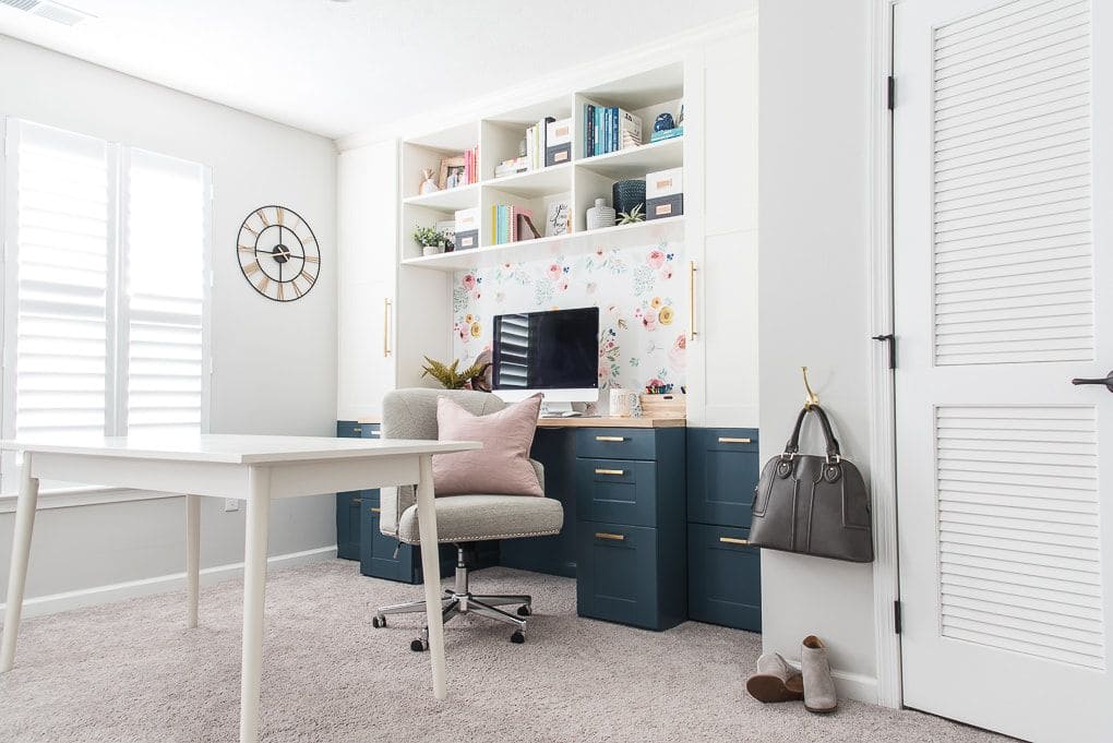 overhead storagw in an office setup table chair and books placed in shelves