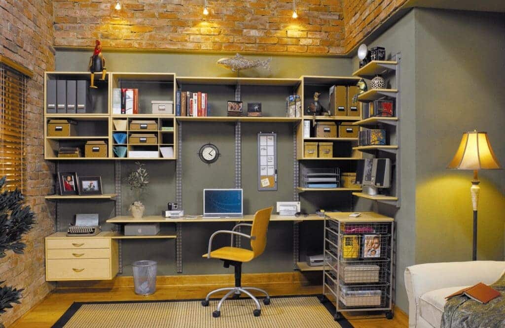 vertical shelving in office setup files annd books in shelves monitor placed on desk with chair and lamp