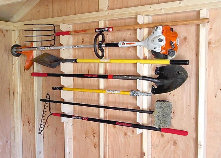 wall mounted tool rack different gardening tools hung on it