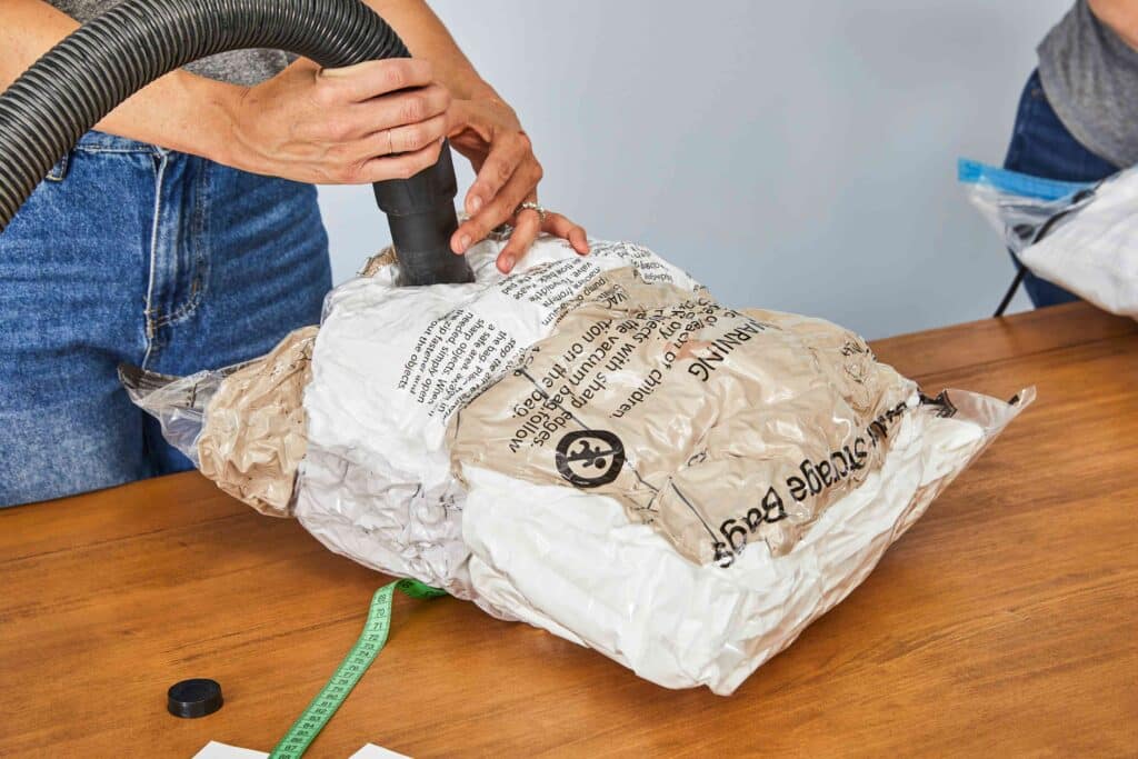 A view of a person using an air pump on a vacuum storage bag