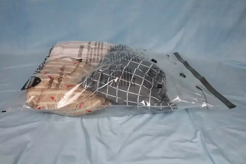 A view of a plastic clear vacuum storage bag with clothing items in it