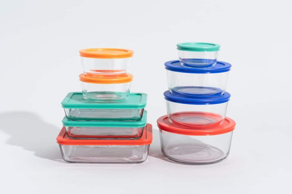 A view of glass containers on top of each other with colorful lids