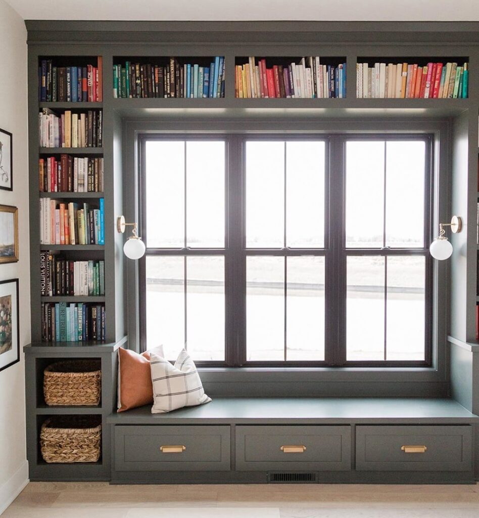 books arranged alongside window seat