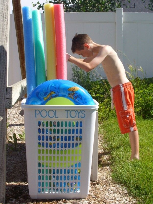 A view a kid standing bby the pool hamper for toys