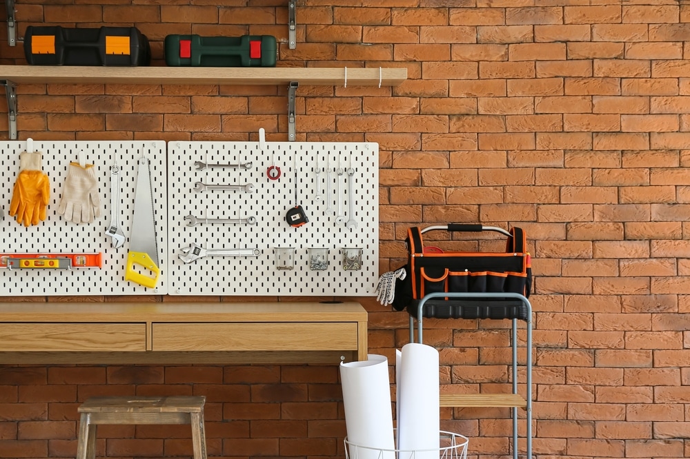 A front view of a pegboard wall in a basement for storage 