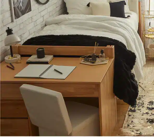 A view of a desk furniture inside a dorm bed room