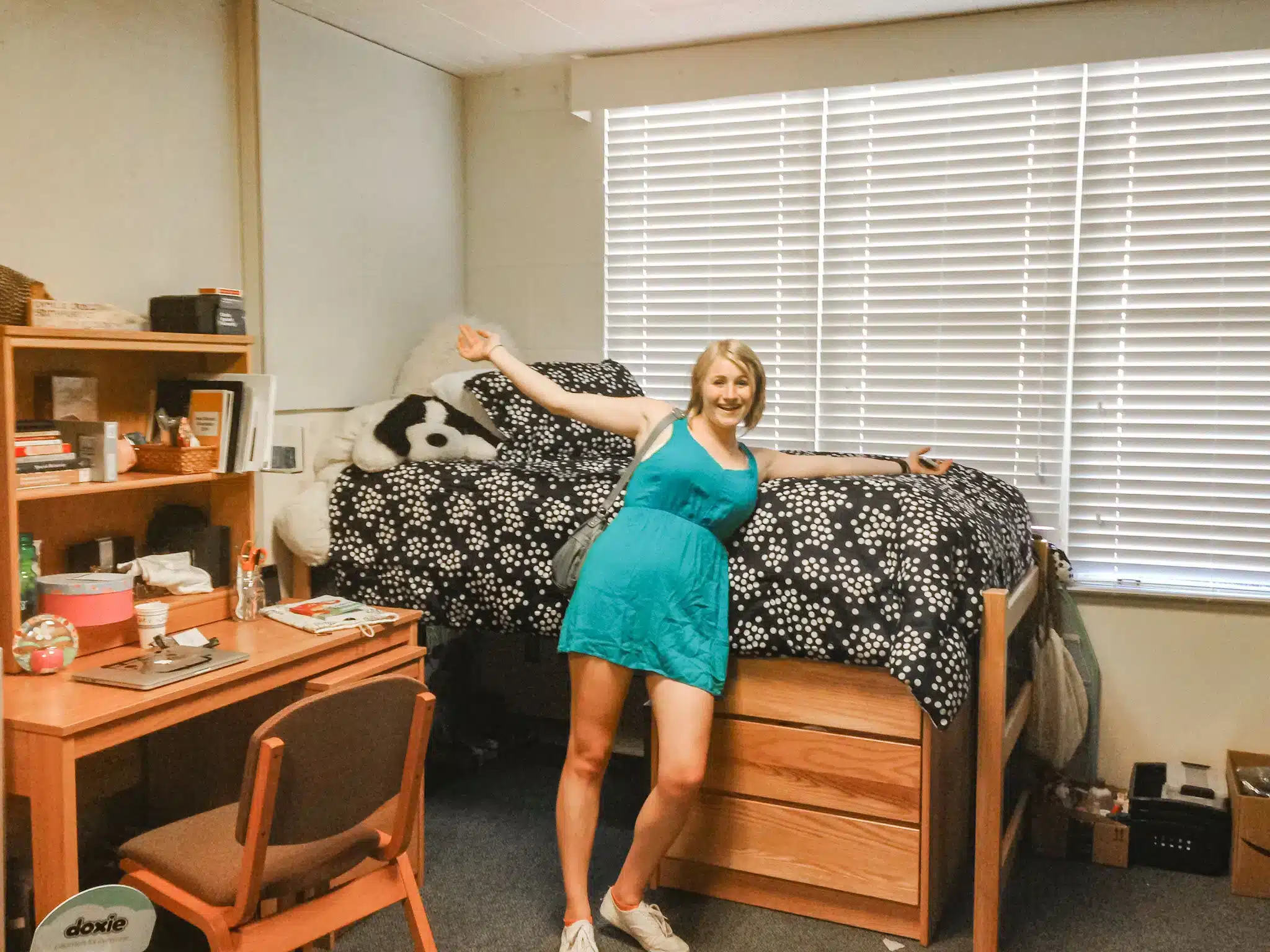 A view of a girl leaning by the bedside in a dorm room jpg