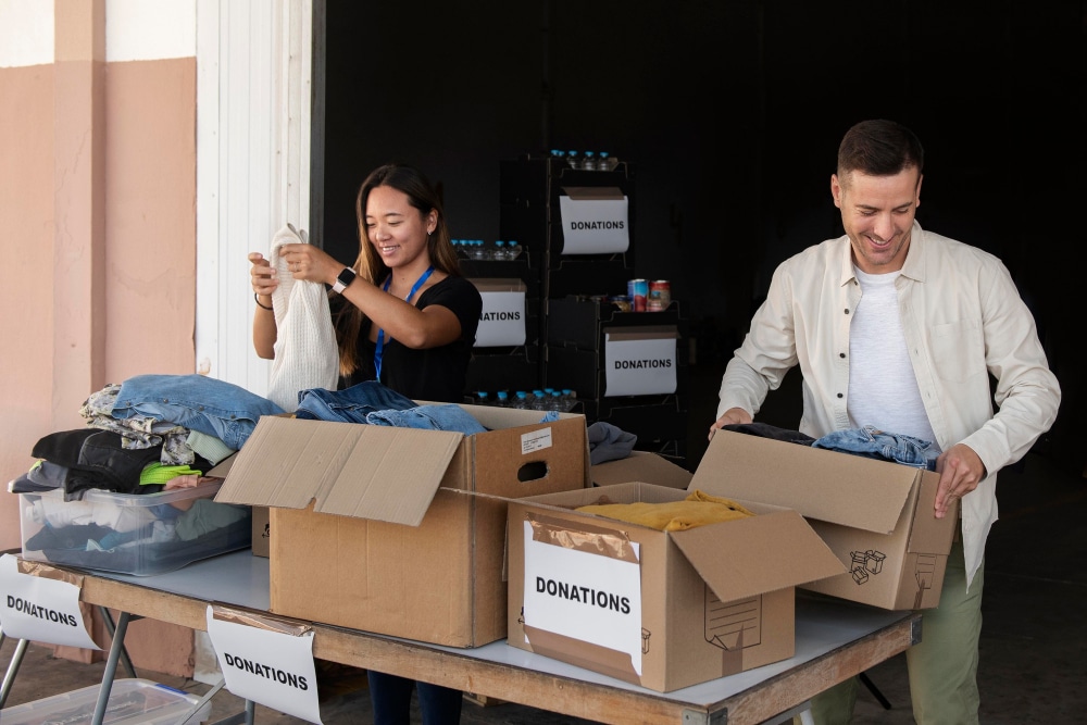 A view of a guy and a girl putting storage stiff in labeled boxes inisde a basement