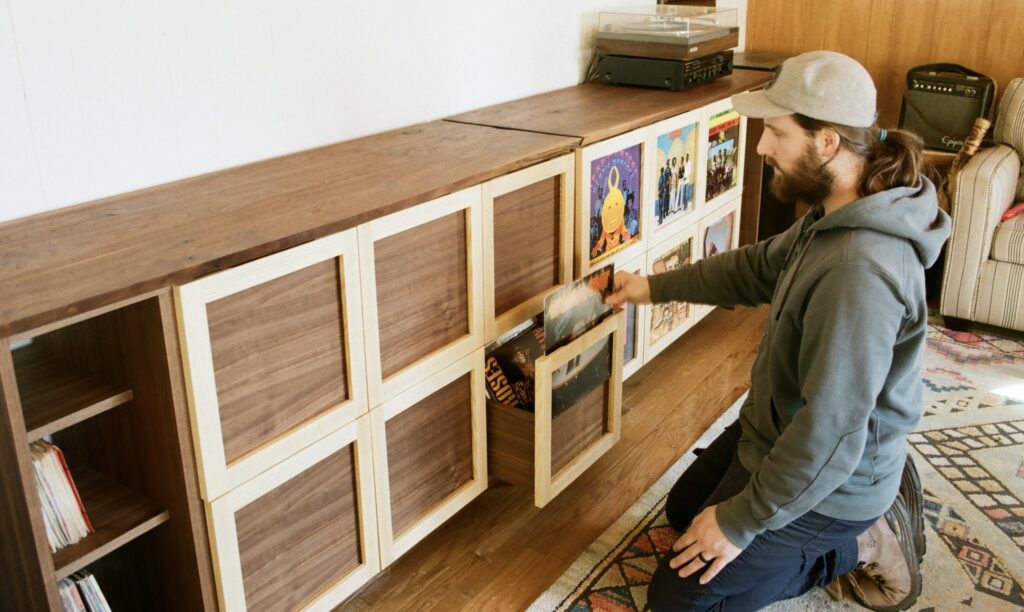 A view of a person putting record labels inside a wooden cabinet