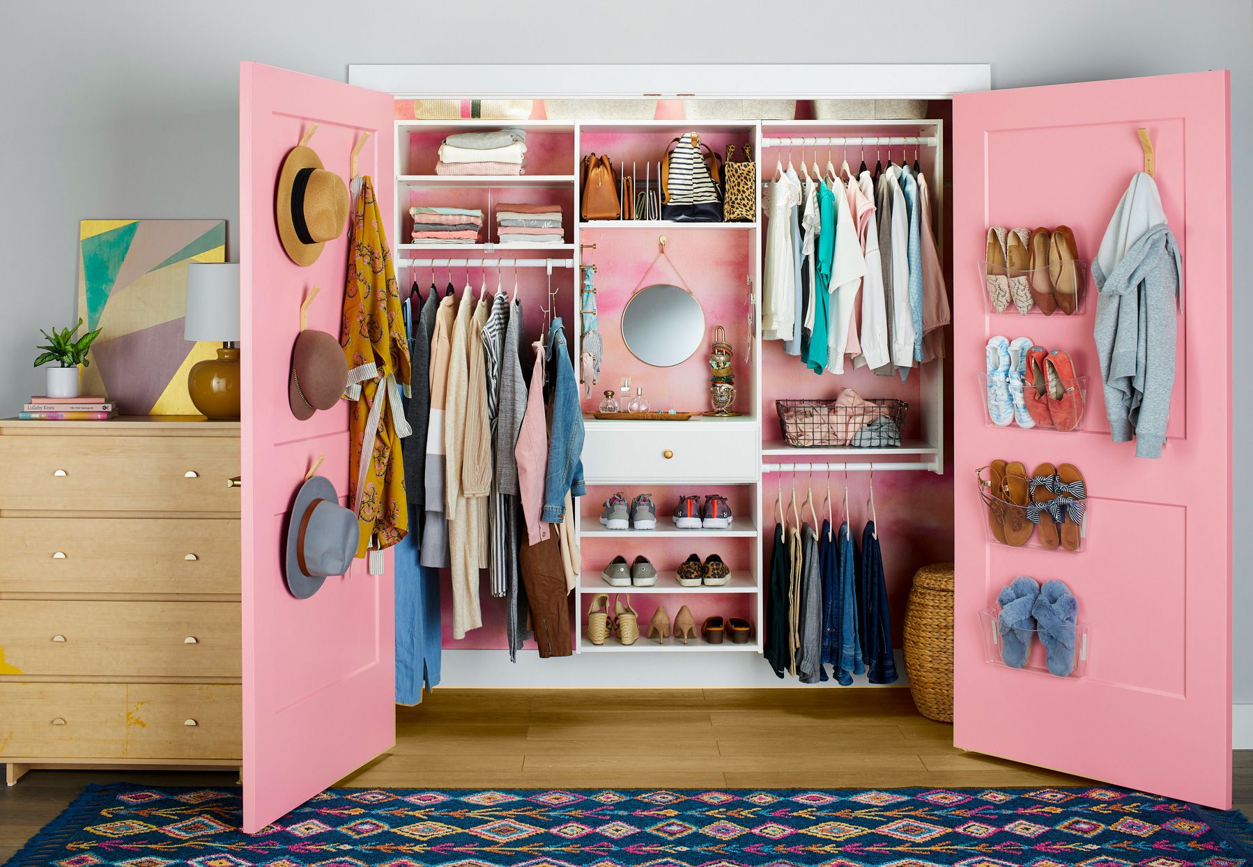 A view of a pink closet space stored with clothes