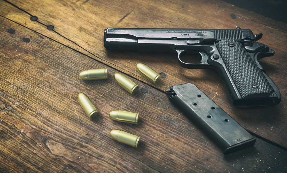 A view of a a 9mm pistol and some bullets