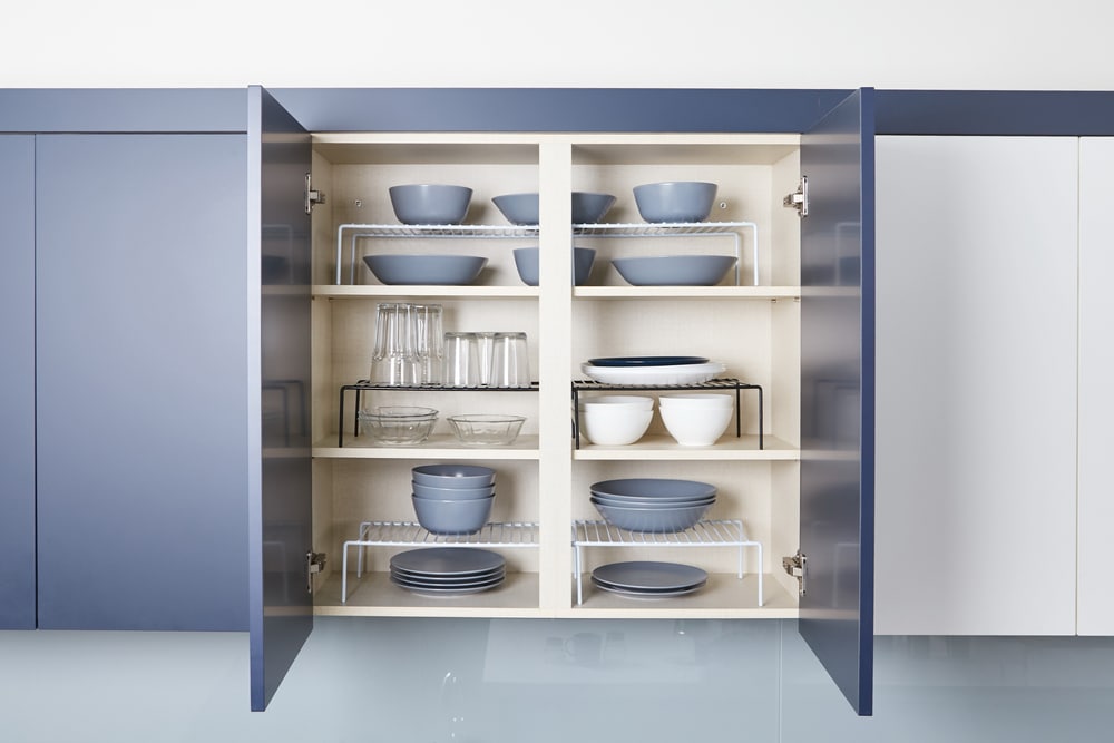 A view of neatly placed plates and glasses inside a kitchen cabinet