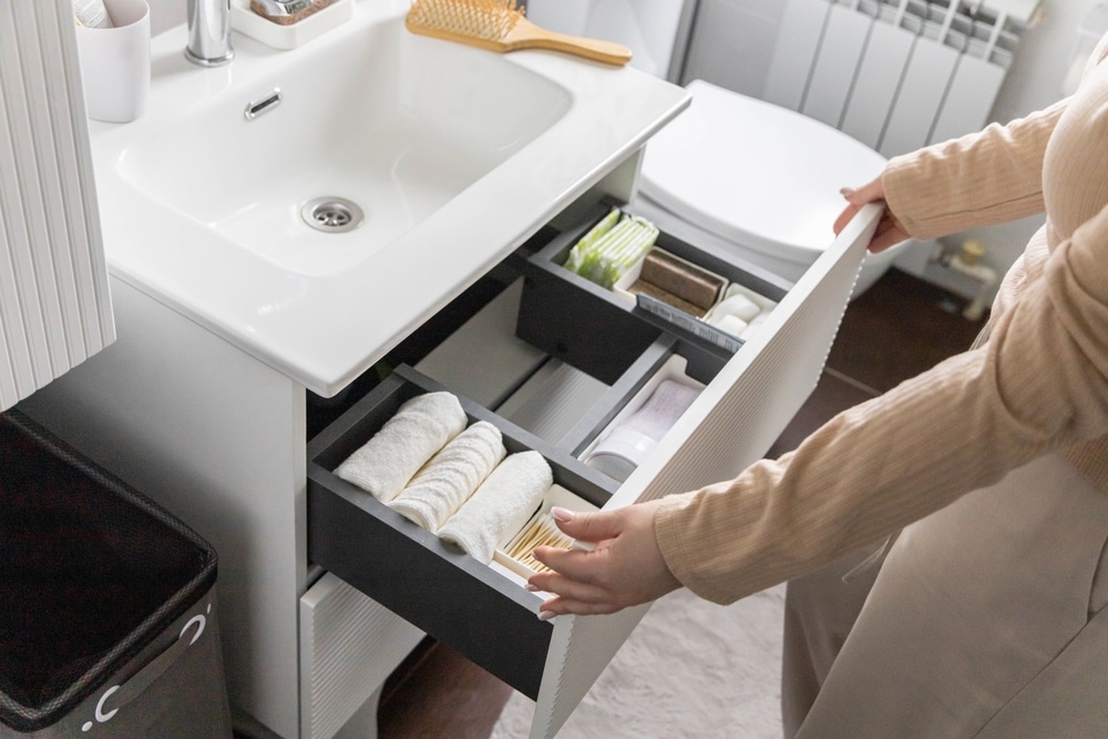 A view of towels neatly rolled inside a bathroom drawer